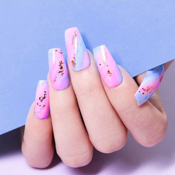 Paznokcie w stylu Pastel Wash i Aura Nails z różowo-błękitnym efektem oraz złotymi płatkami o kształcie Ballerina