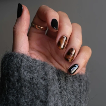 Amber brown tortoiseshell nails on long almond-shaped nails