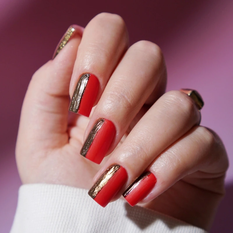 Ongles rouges avec détails chromés dorés sur les côtés
