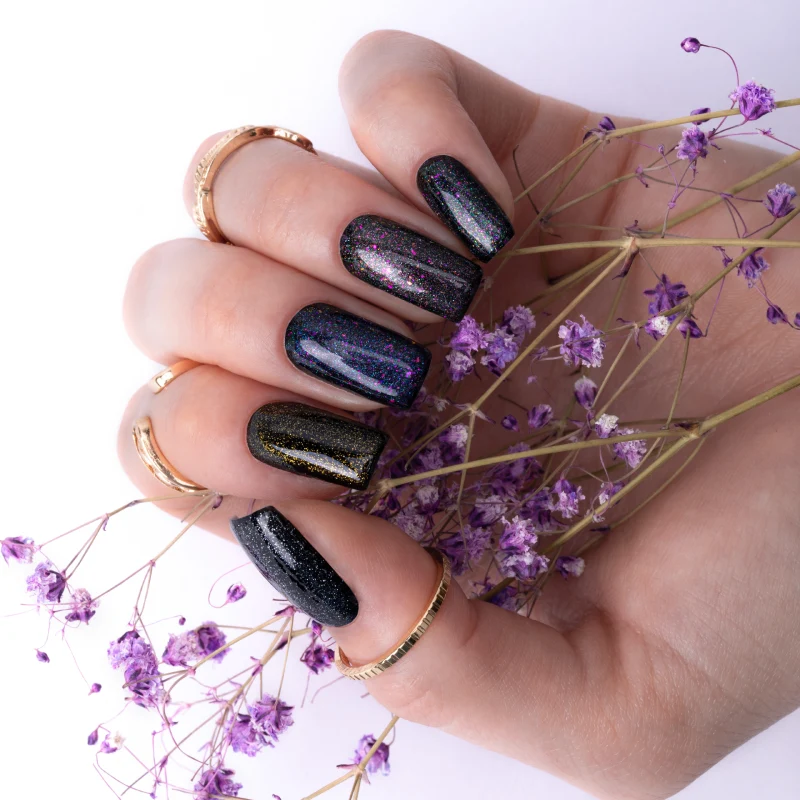 Dark nails with multicoloured glitter shimmer and purple accents