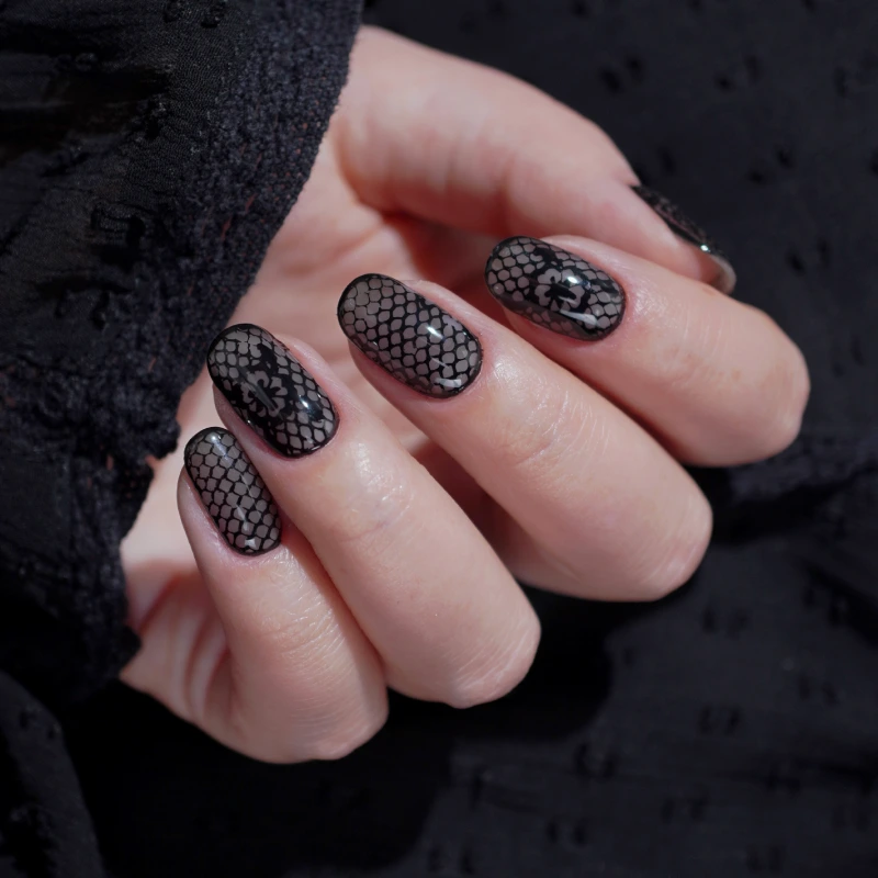 Black nails with a lace pattern and subtle shimmer