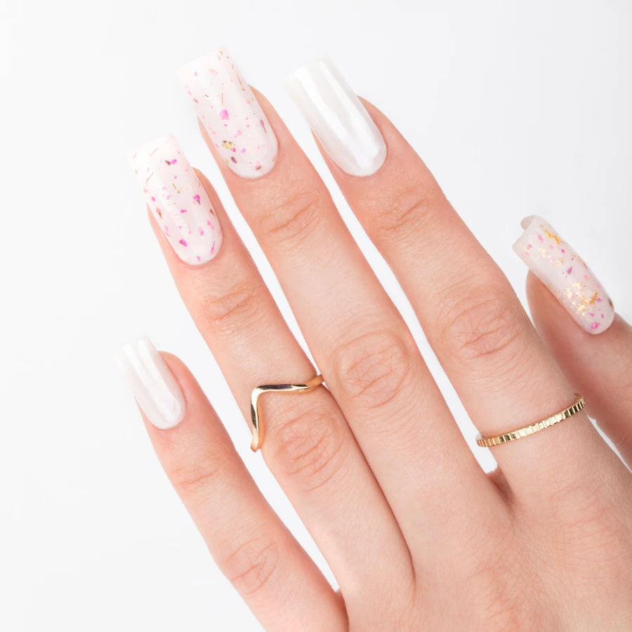 White bridal nails with delicate petals and gold detailing.