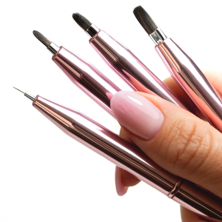 dłoń trzymająca pędzelki do nail artu