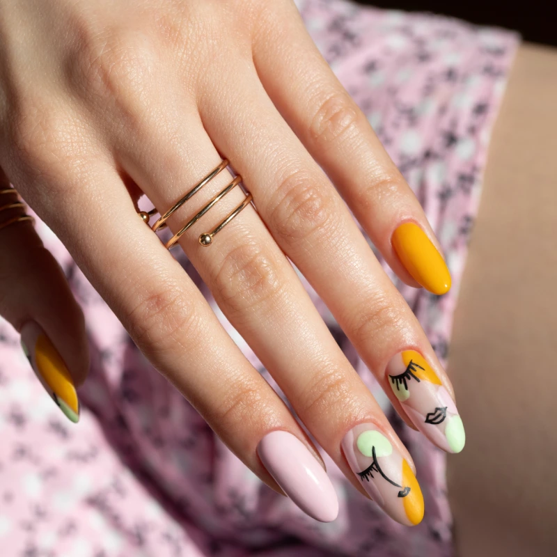 Line art nails z motywem twarzy i asymetrycznym color blockingiem