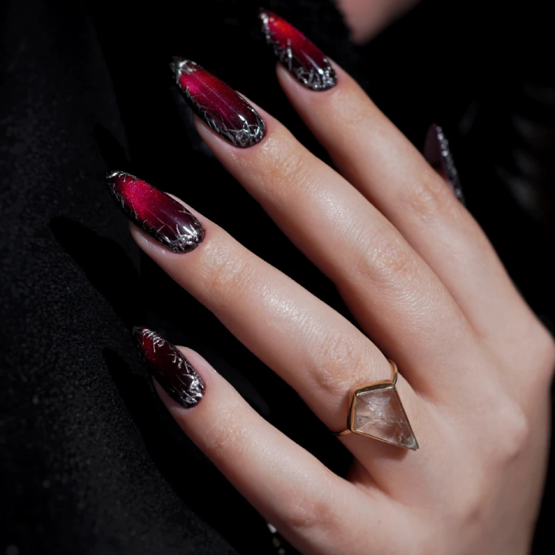 Red and black nails with metallic details and a Cat Eye effect