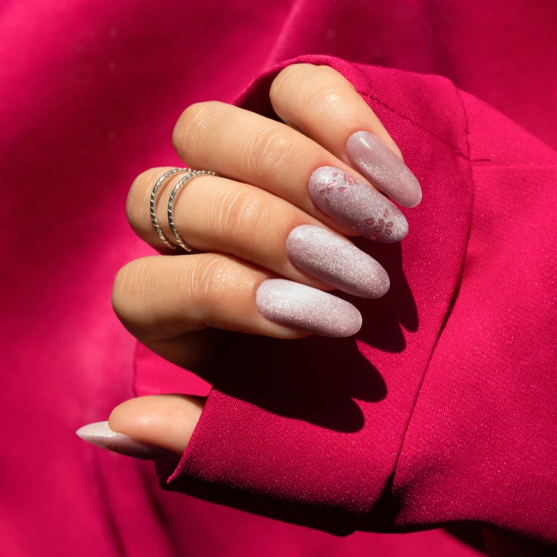Różowy manicure Cat Eye na długich migdałowych paznokciach z subtelnym kwiatowym zdobieniem