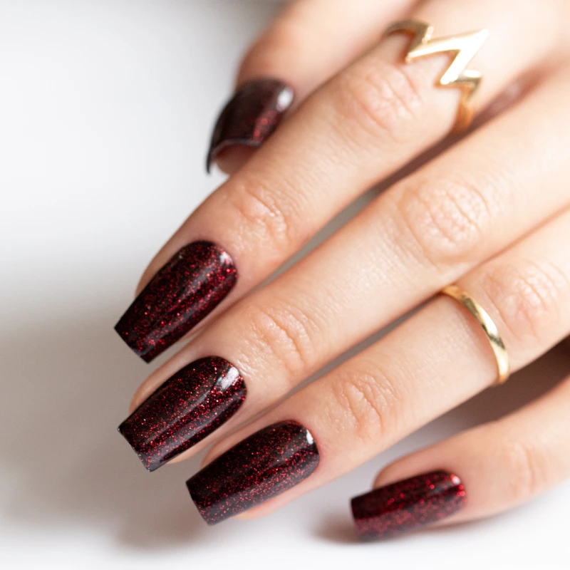 Czarno-bordowy manicure na długich kwadratowych paznokciach z czerwonymi, brokatowymi drobinkami