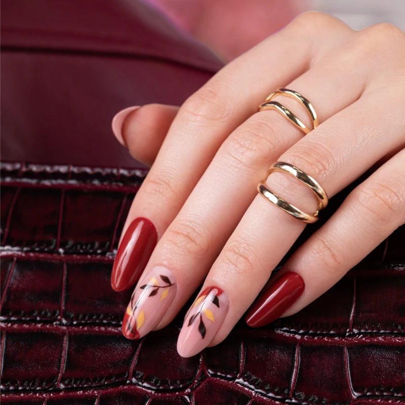 Burgundy nails with an autumn botanical design in shades of brown, yellow and red.