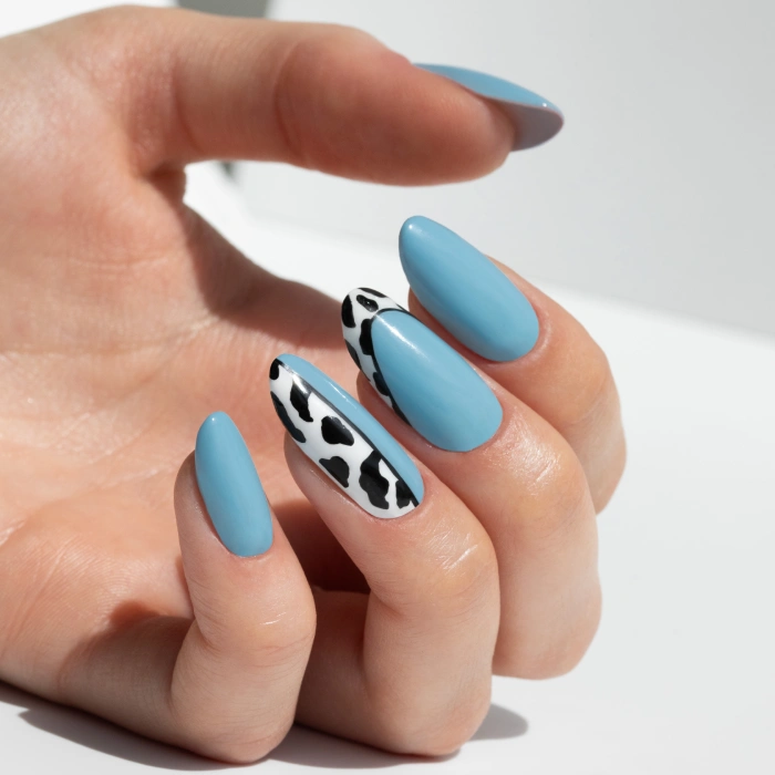 Blue nails with a black-and-white cow print animal design
