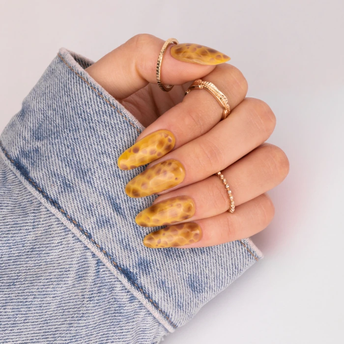 Yellow and amber animal-print nails with a giraffe-inspired pattern