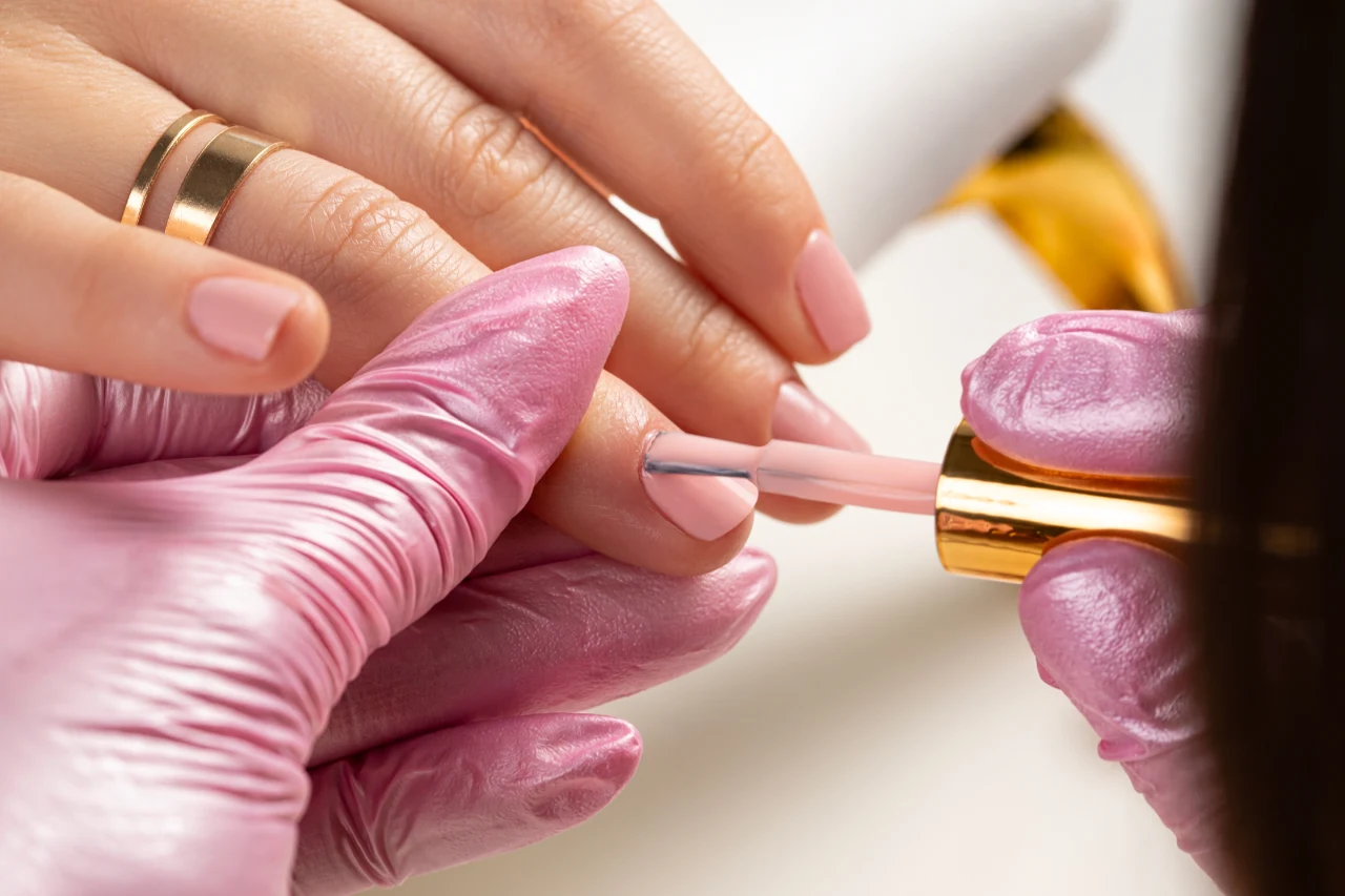 zbliżenie na wykonywanie manicure klasycznego w odcieniach nude