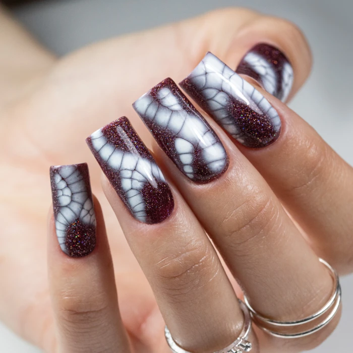 Burgundy nails with a white reptile-inspired animal-print design
